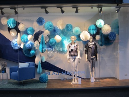 décoration de noël - vitrine de magasin décorée avec des boules et des rosaces en papier crépon bleu